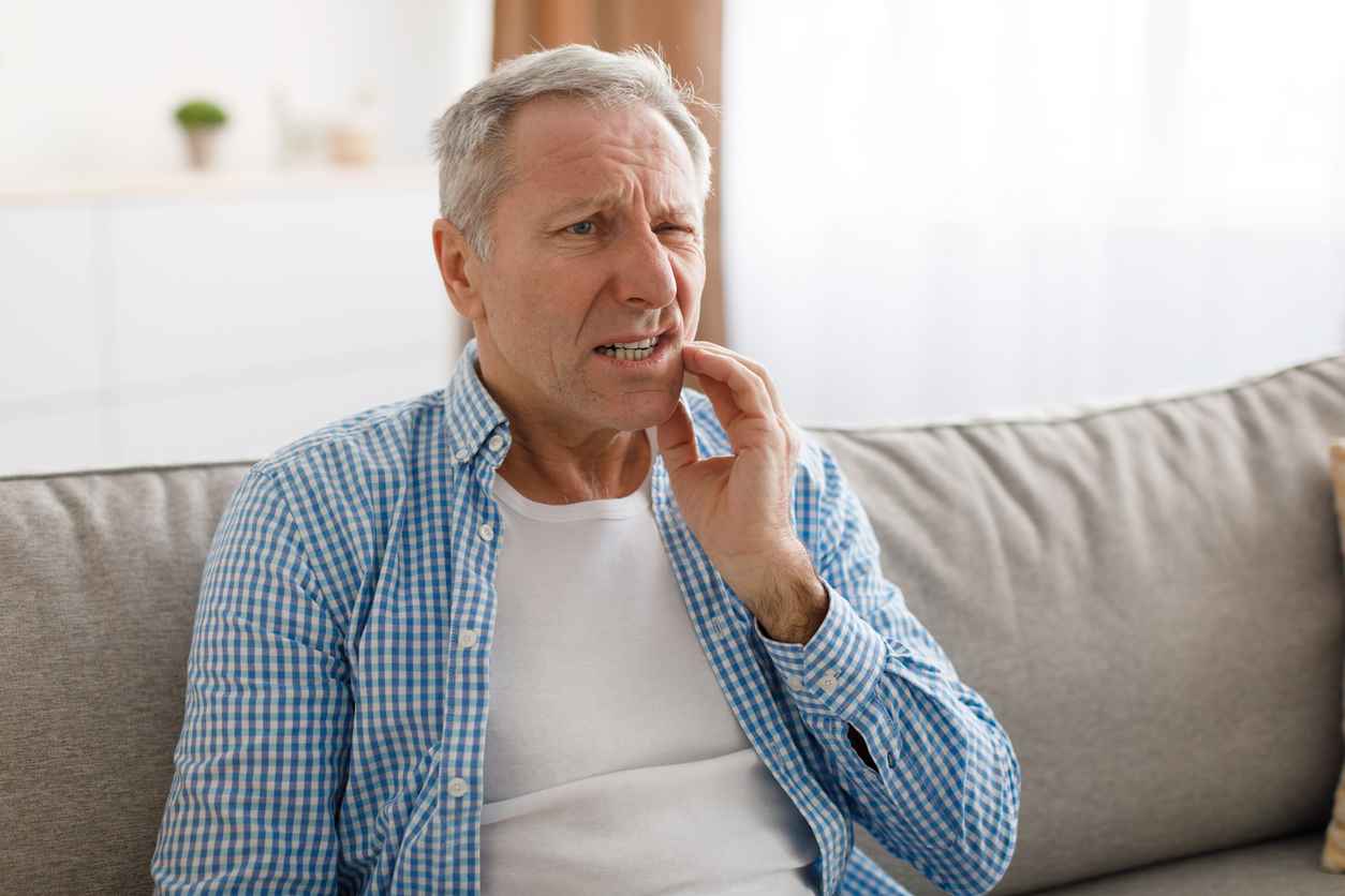 Portrait of unhappy mature man suffering from toothache